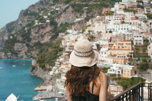 A woman standing on a balcony looking at the ocean
