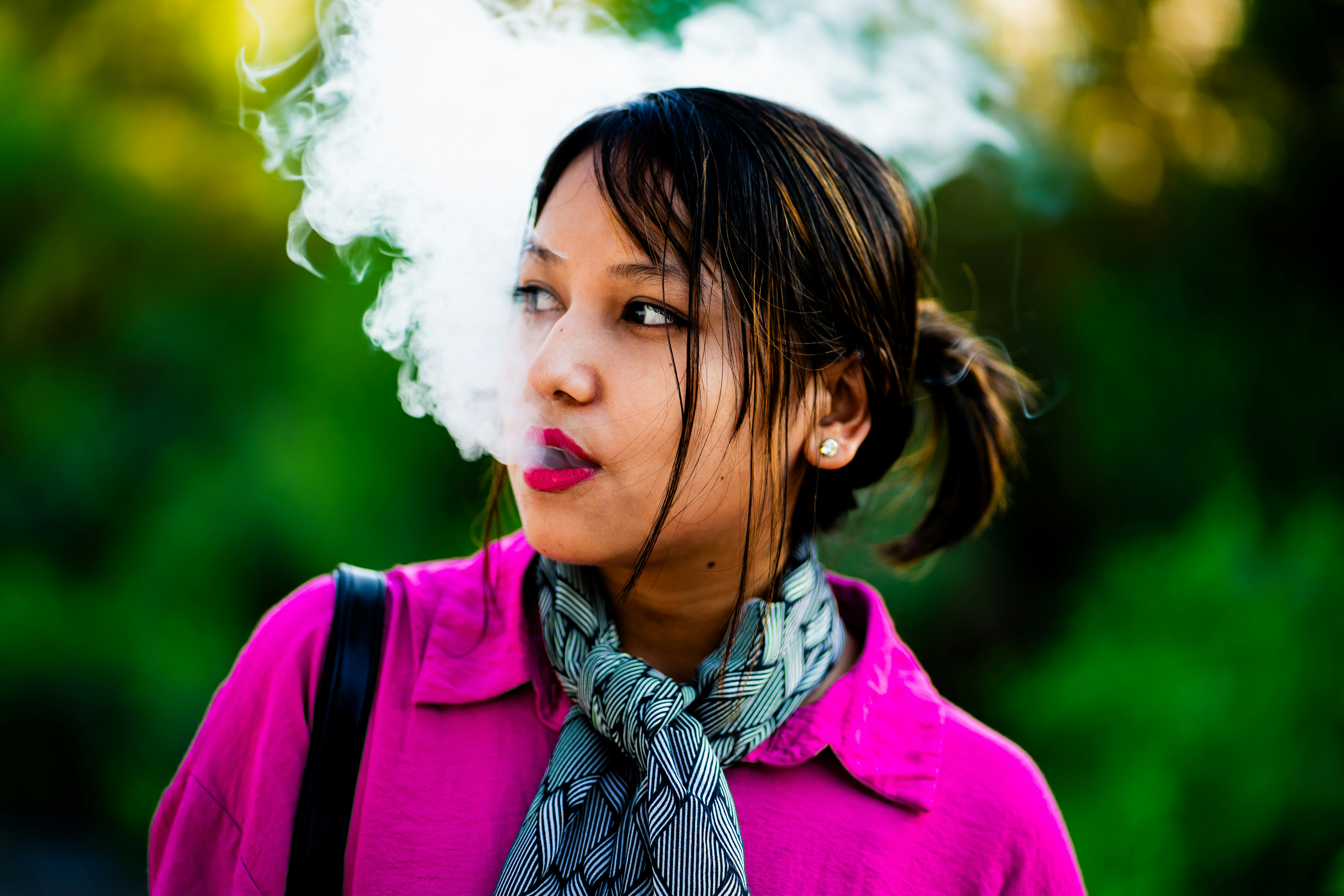 Una donna in una giacca rosa che fuma una sigaretta