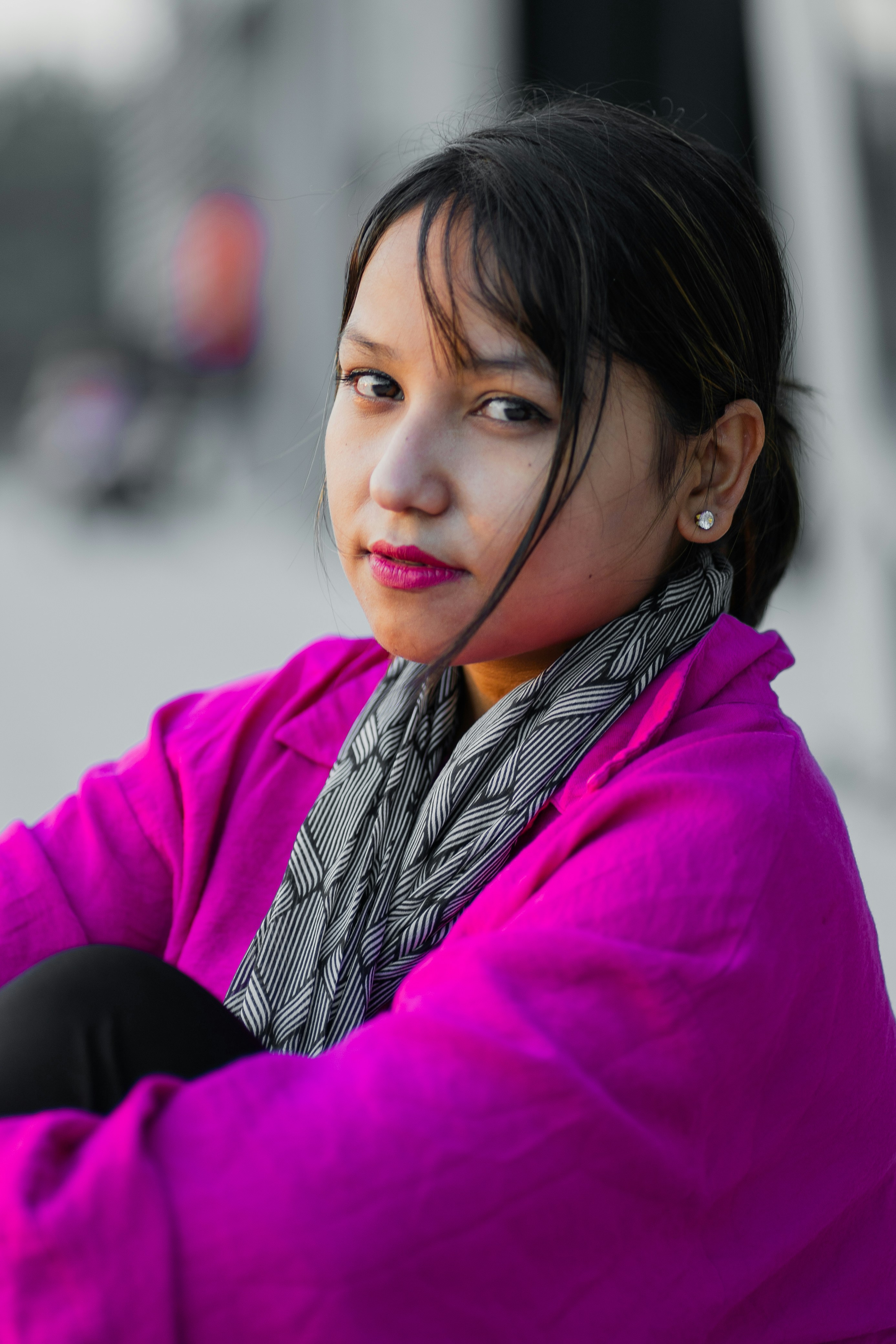 A woman wearing a purple jacket and scarf