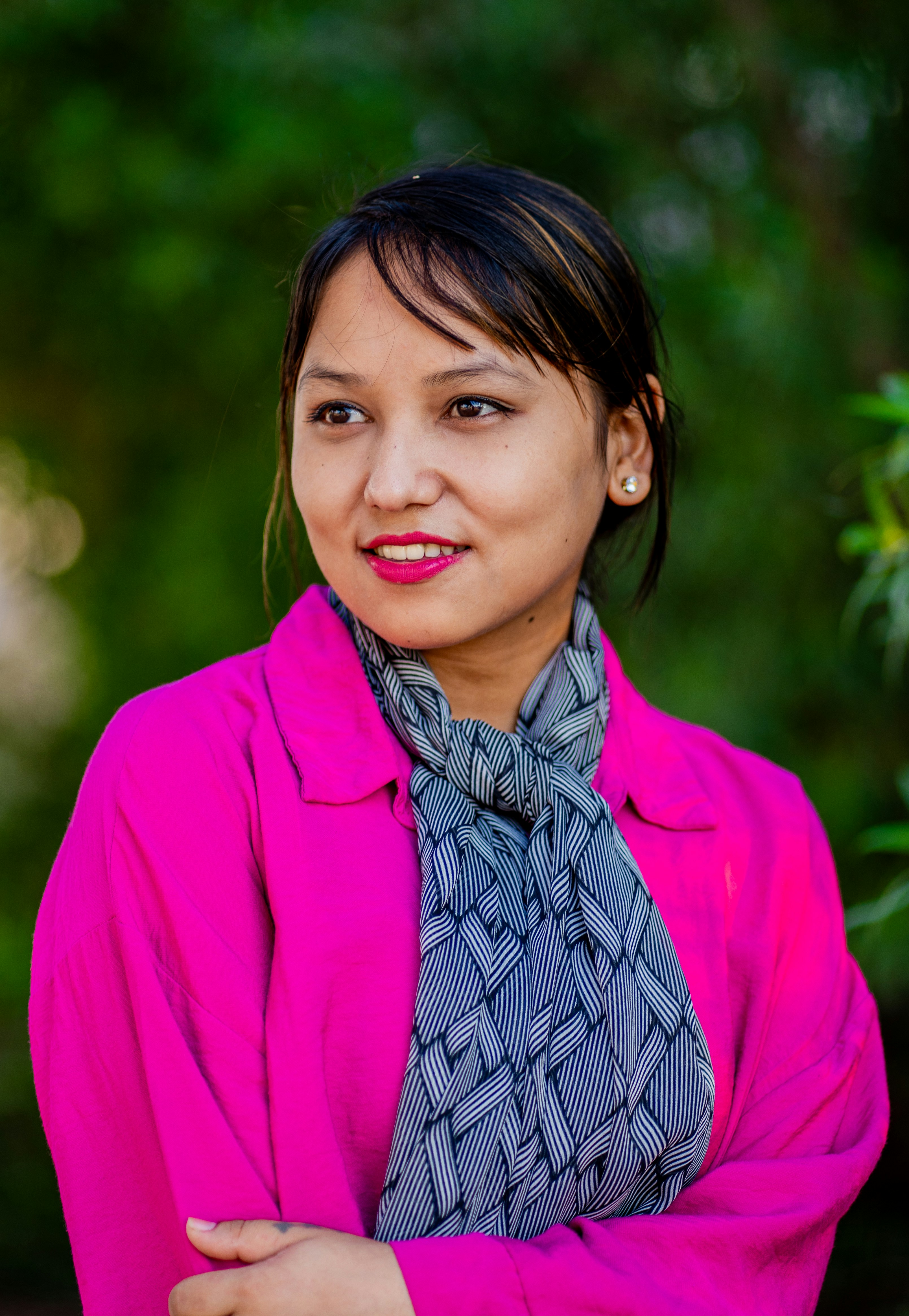 A woman wearing a pink jacket and scarf