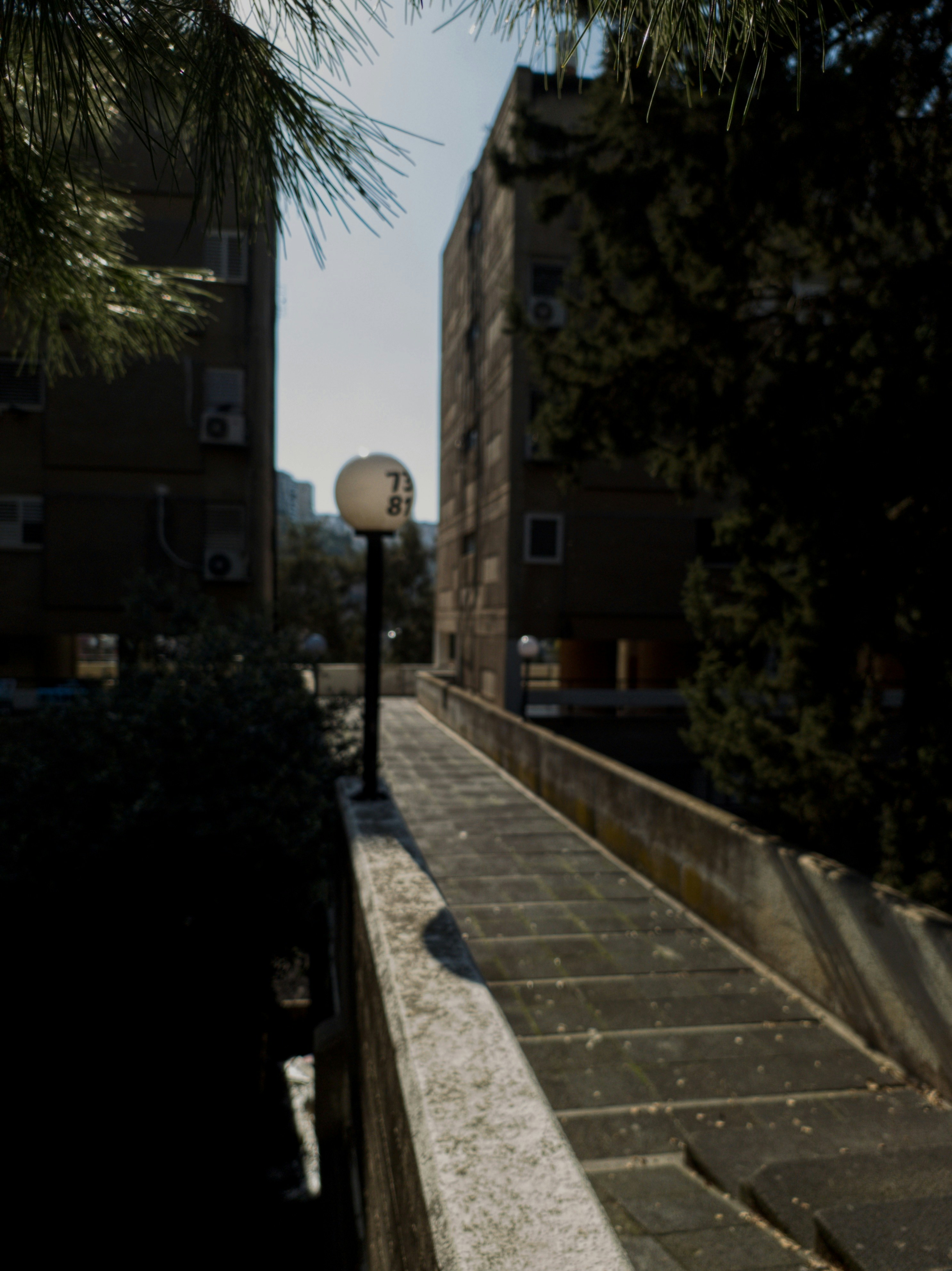 A street light sitting next to a tall building photo – Free Street ...