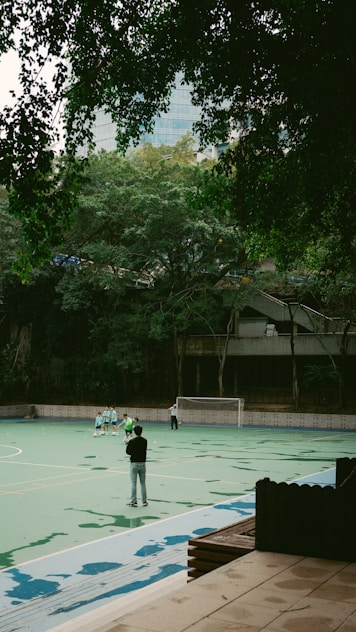 A group of people standing on top of a tennis court