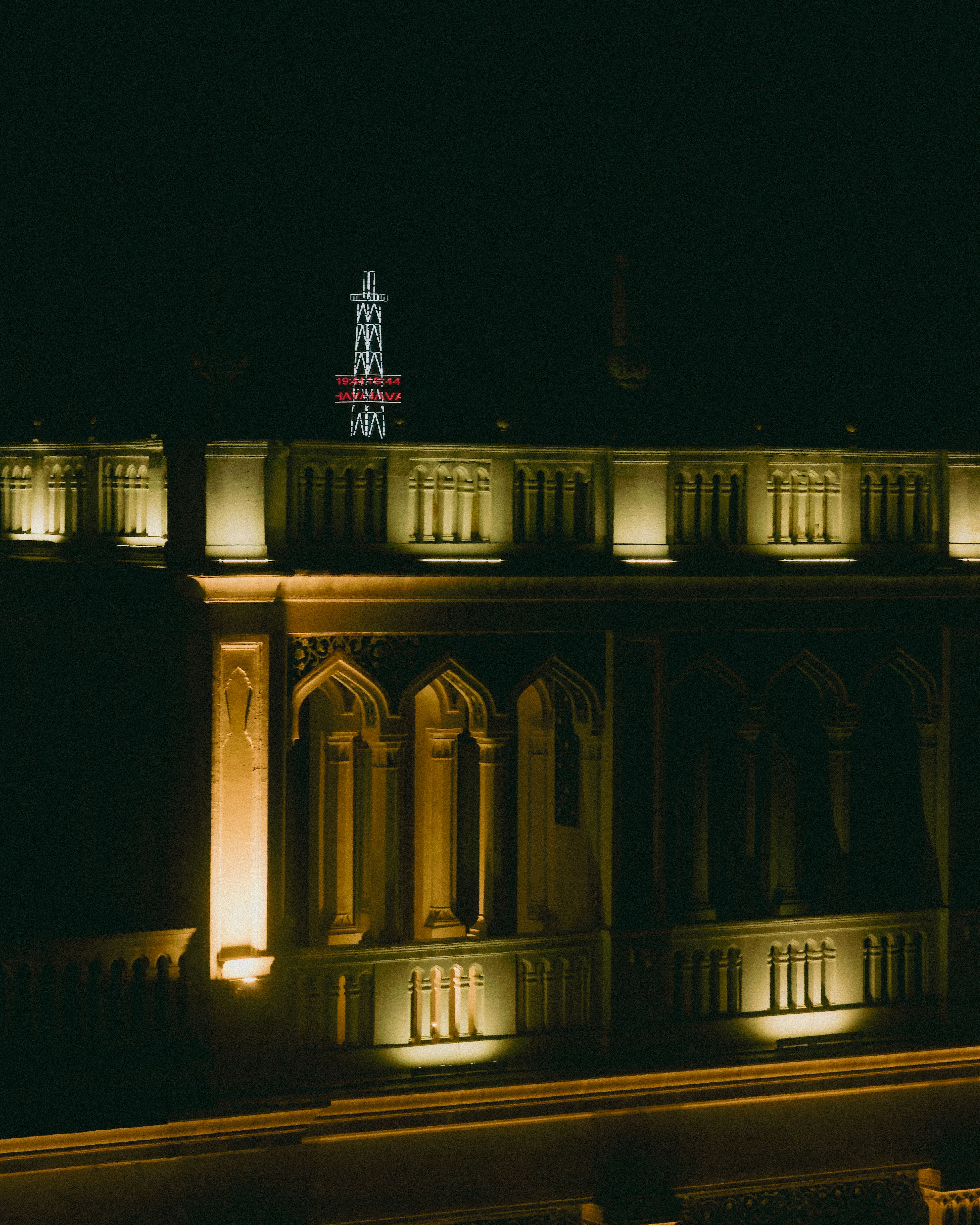 A building lit up at night with a clock on top