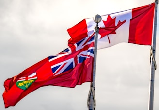 Two canadian and british flags flying side by side