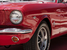 A close up of the front of a red mustang