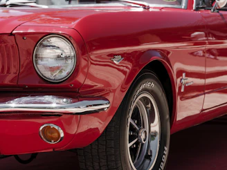 A close up of the front of a red mustang