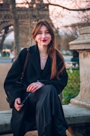 A woman sitting on a bench in front of the eiffel tower