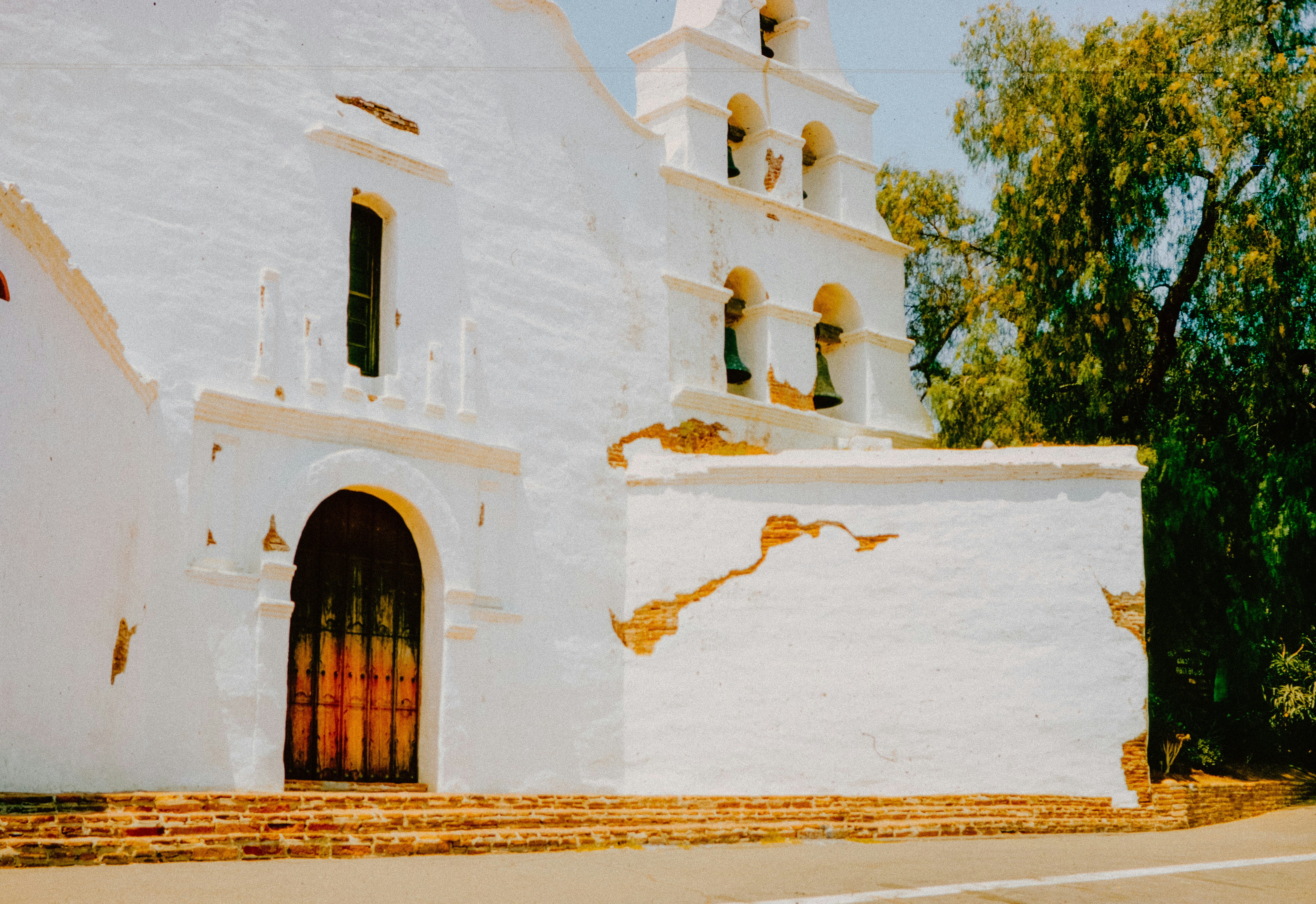 A white church with a red cross on the door