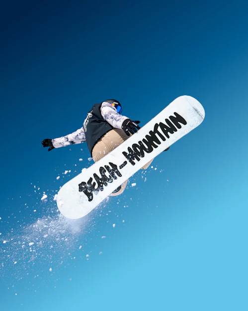 A man flying through the air while riding a snowboard