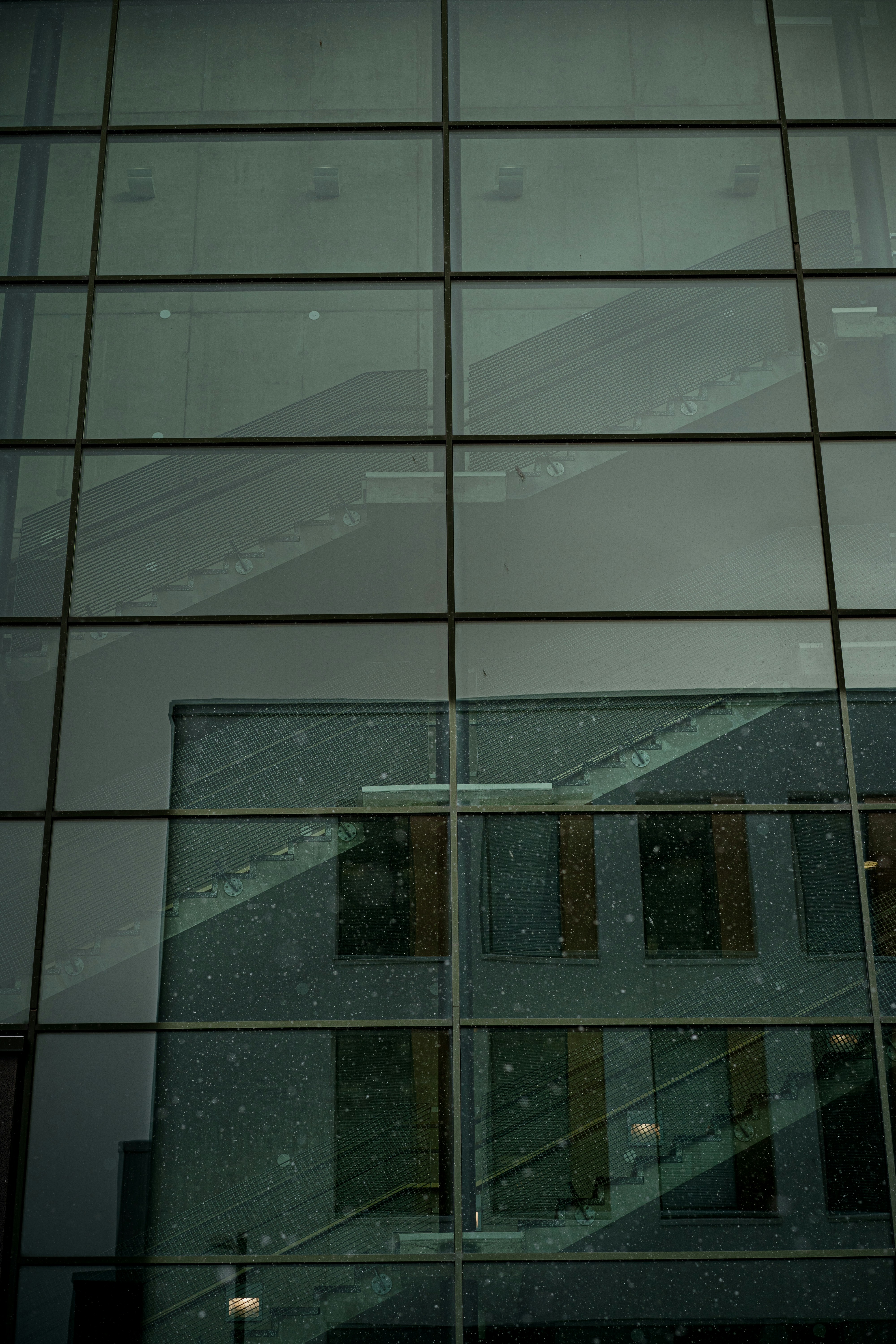 A clock on the side of a glass building