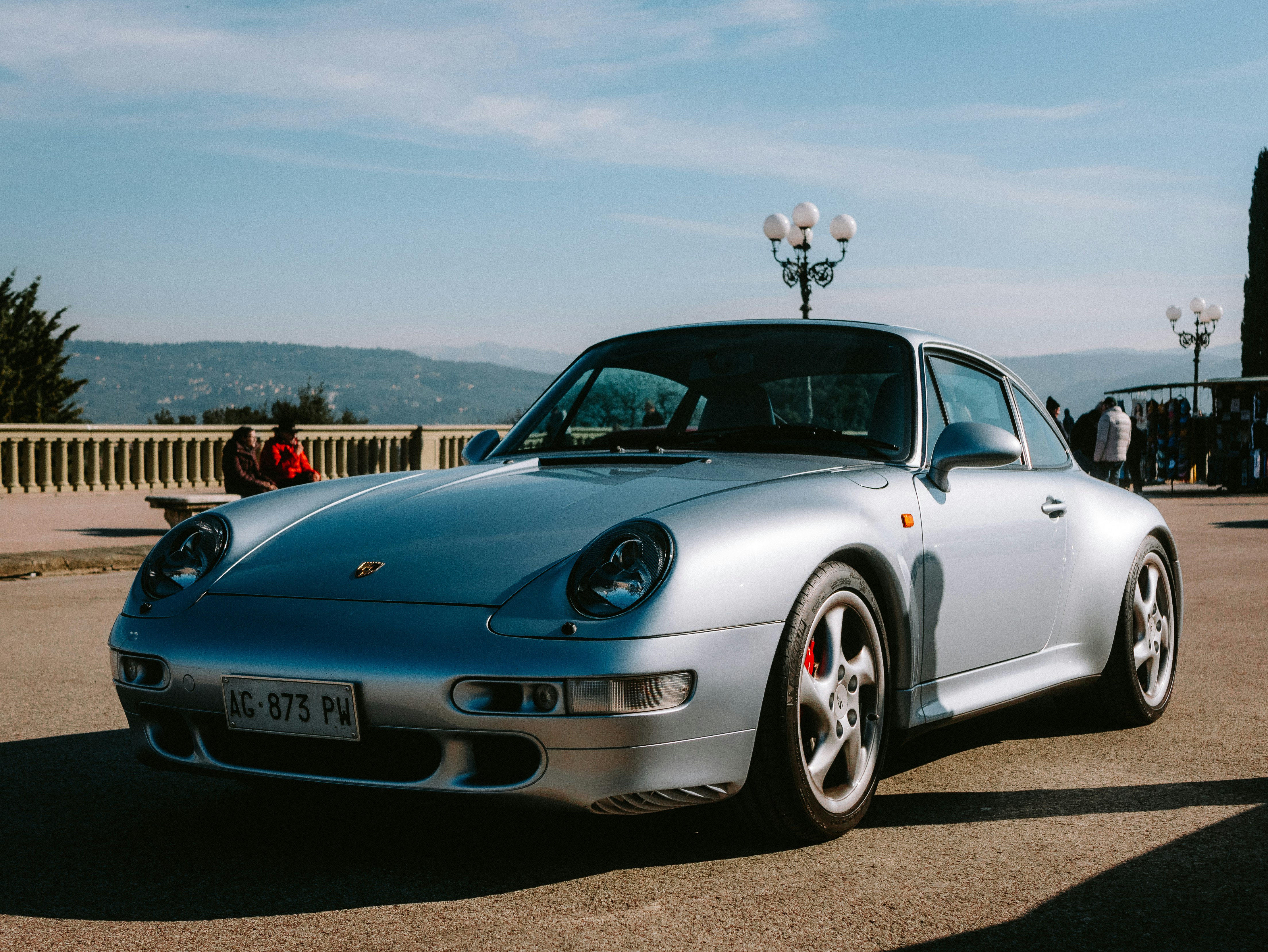 A silver sports car parked in a parking lot