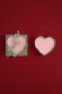 Two heart shaped candles sitting next to each other