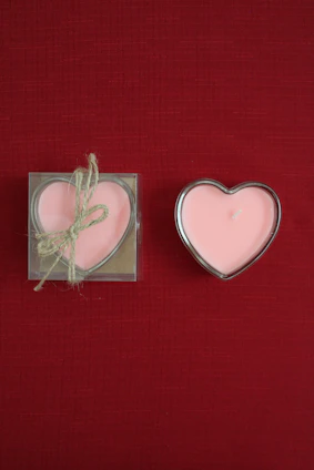 Two heart shaped candles sitting next to each other