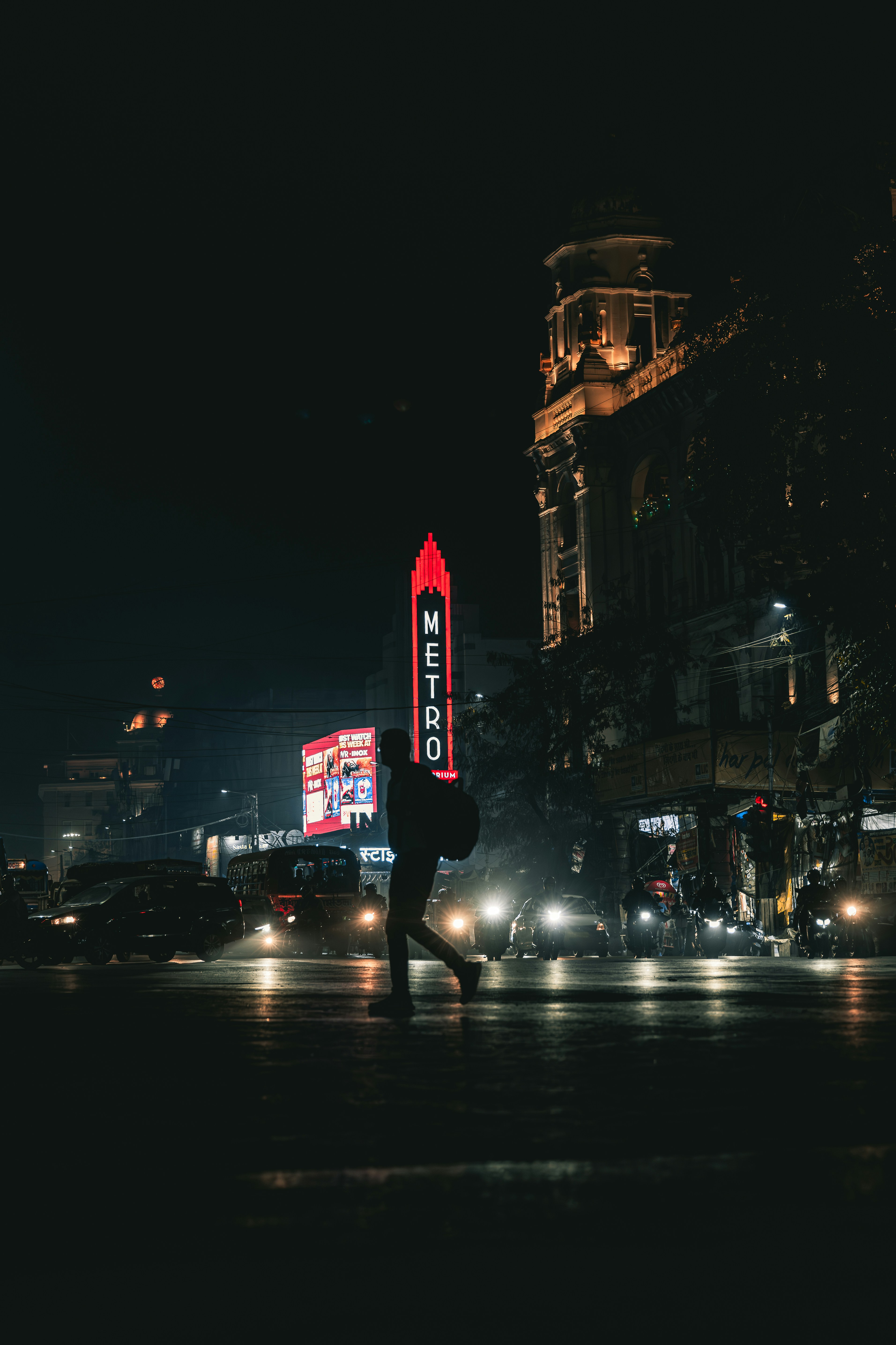A person walking across a street at night