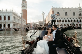A bride and groom ride in a gondola in venice