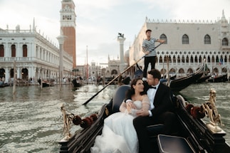 A bride and groom ride in a gondola in venice