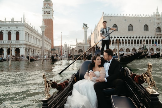 A bride and groom ride in a gondola in venice