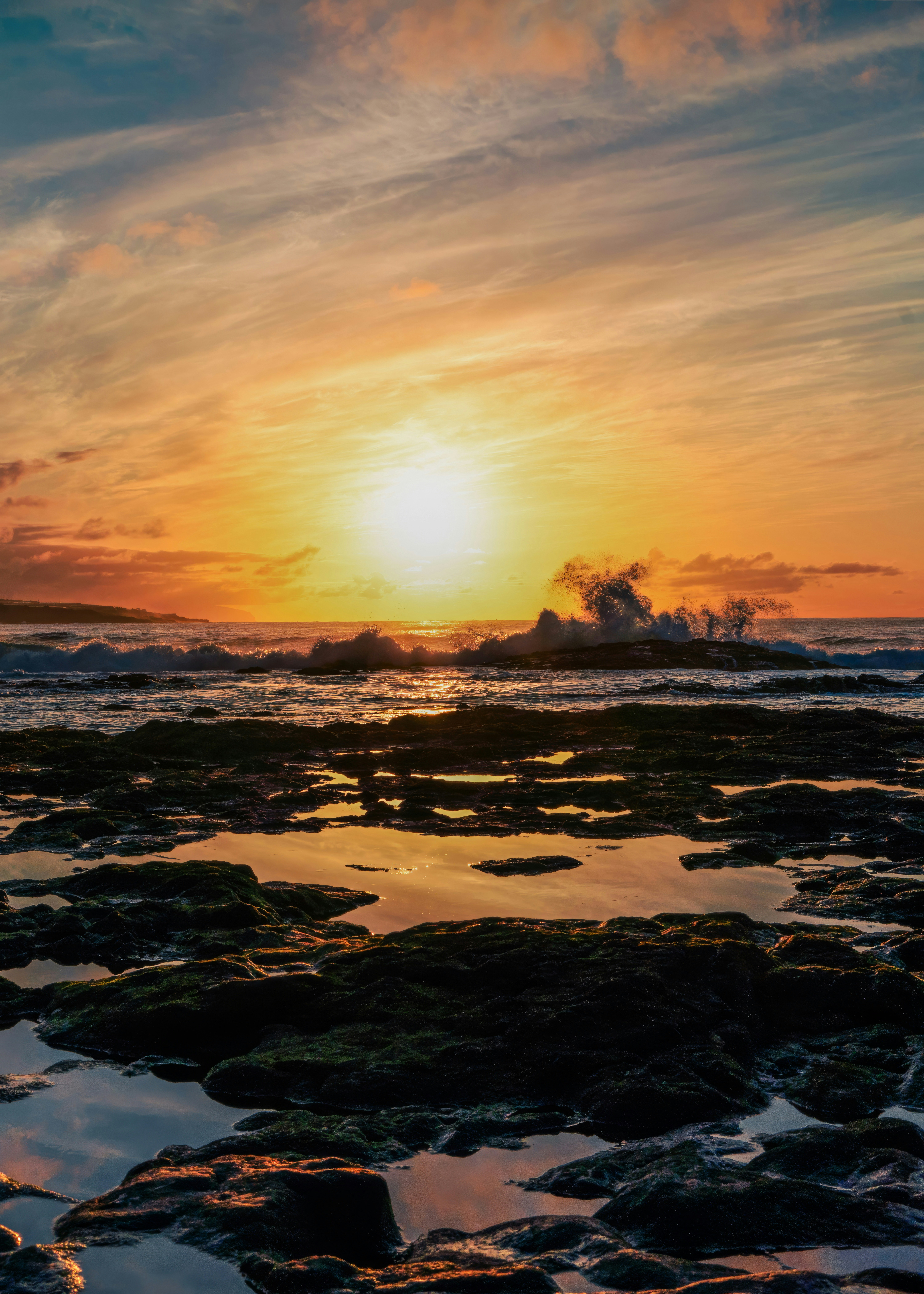Il sole sta tramontando sull'oceano e sulle rocce