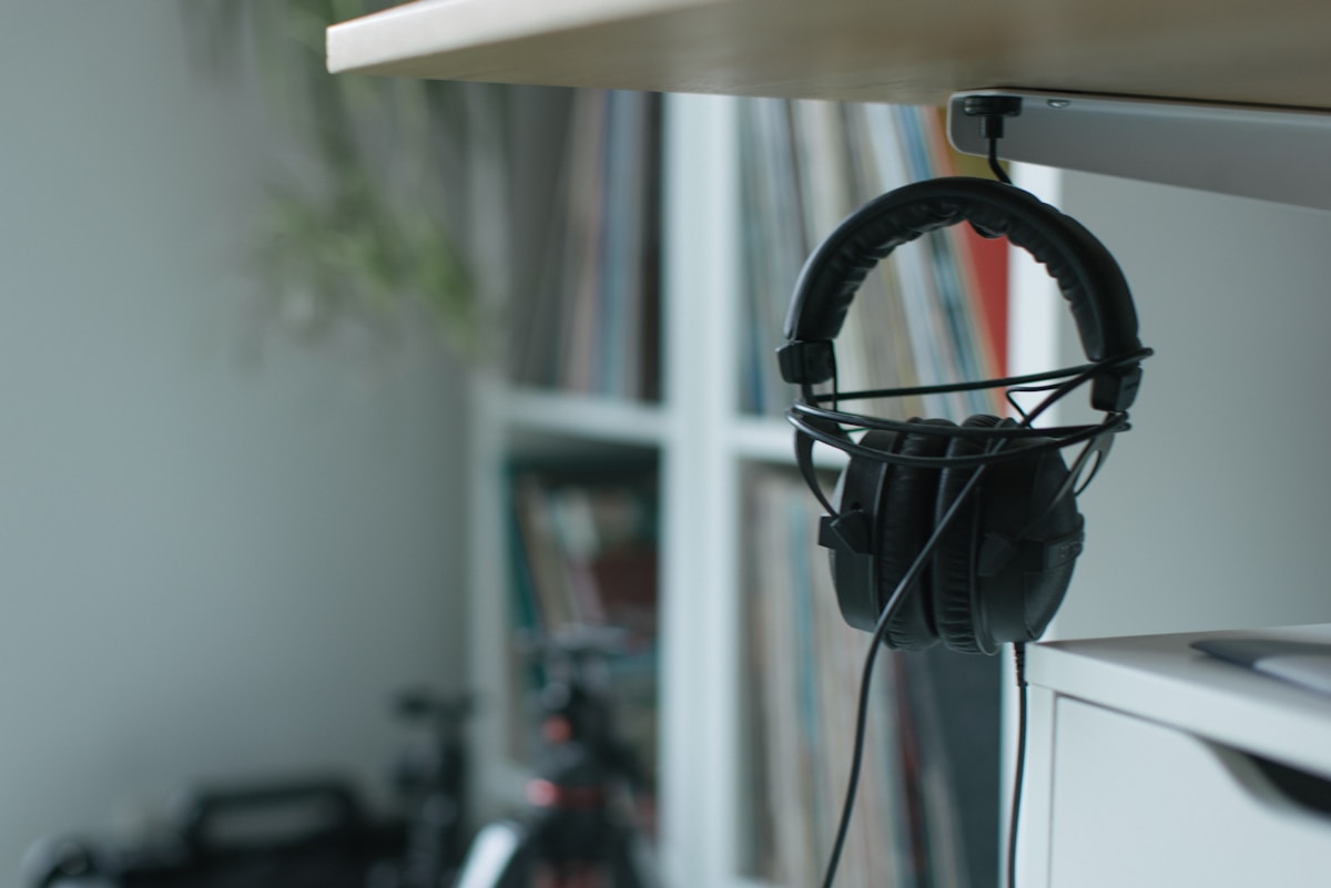 A pair of headphones hanging from a shelf
