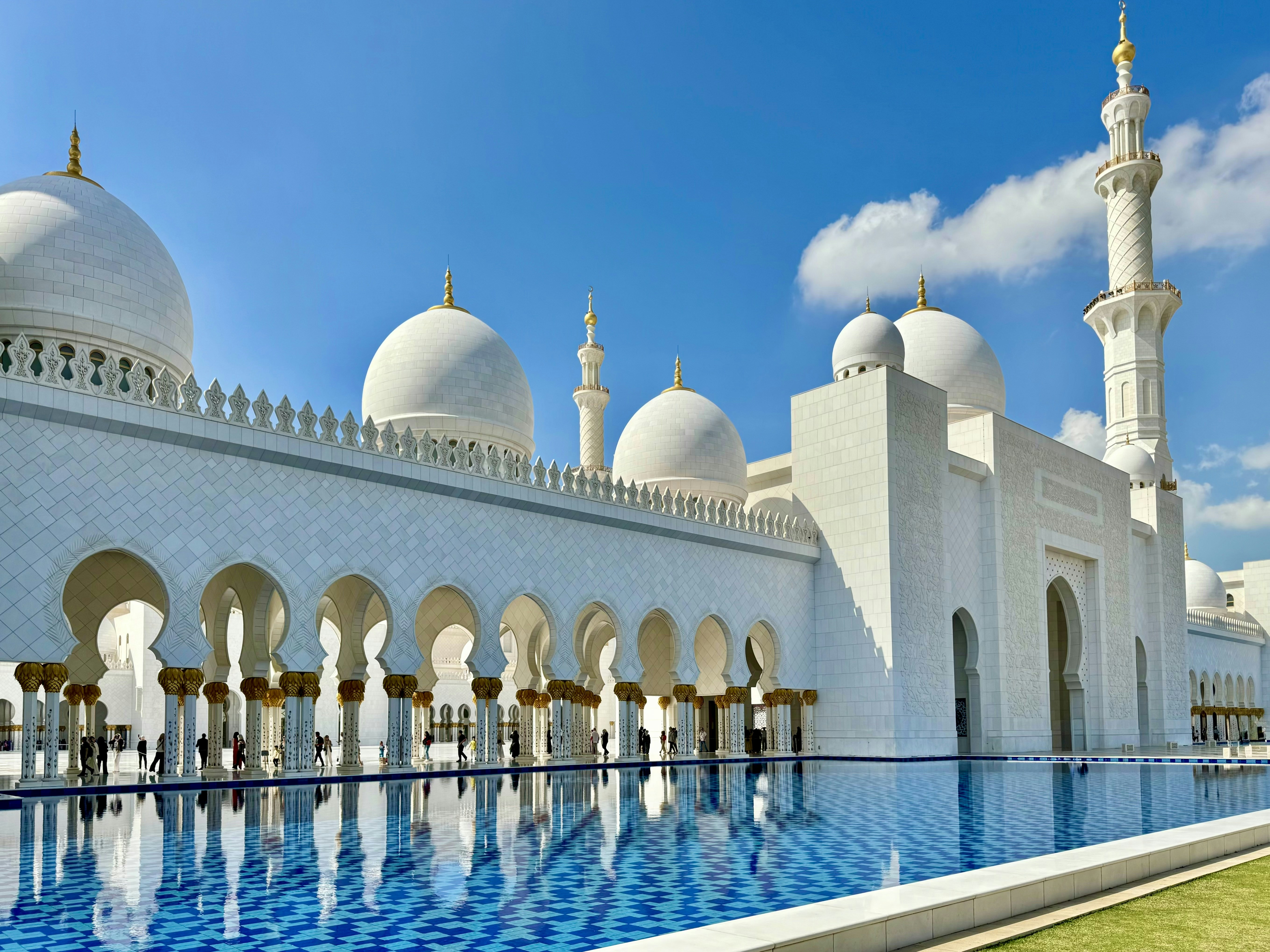 A large white building with a pool in front of it