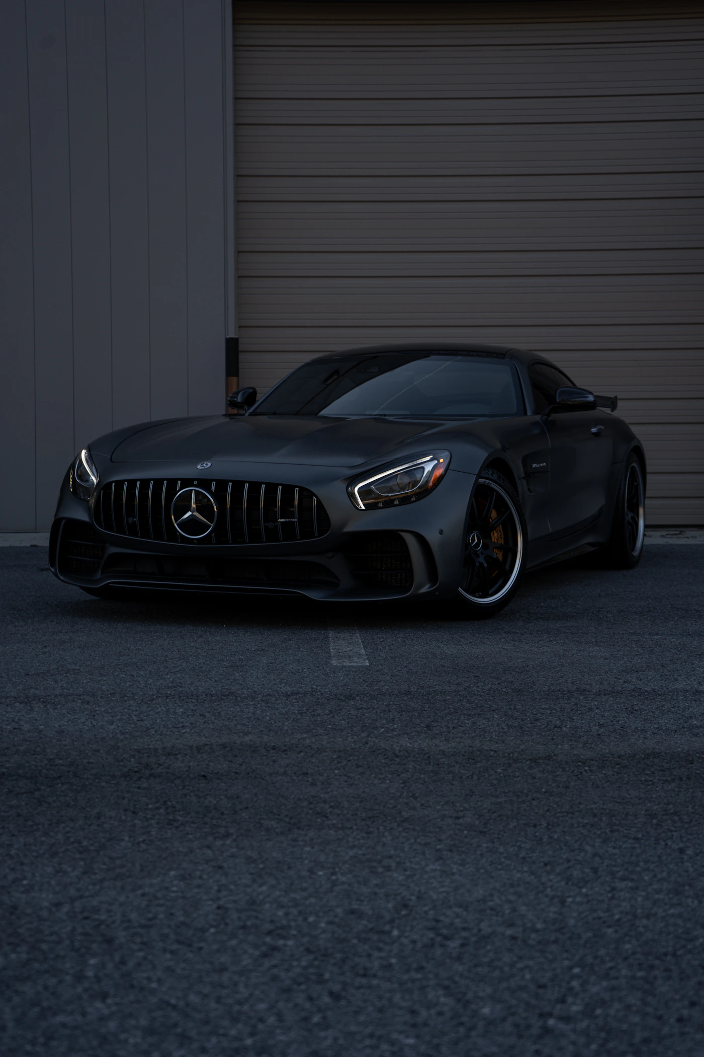 Mercedes-AMG GT preto em frente a uma garagem