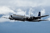 A large airplane flying through a cloudy sky
