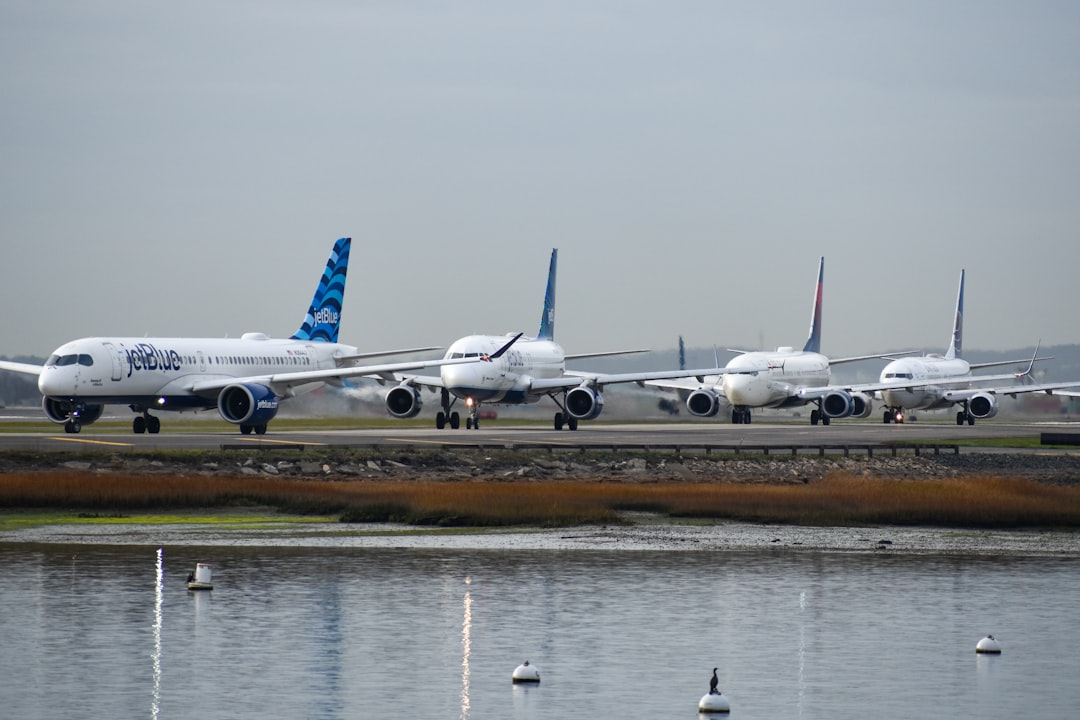 A row of airplanes sitting on top of an airport runway, Planes lining up to take off at Boston Logan