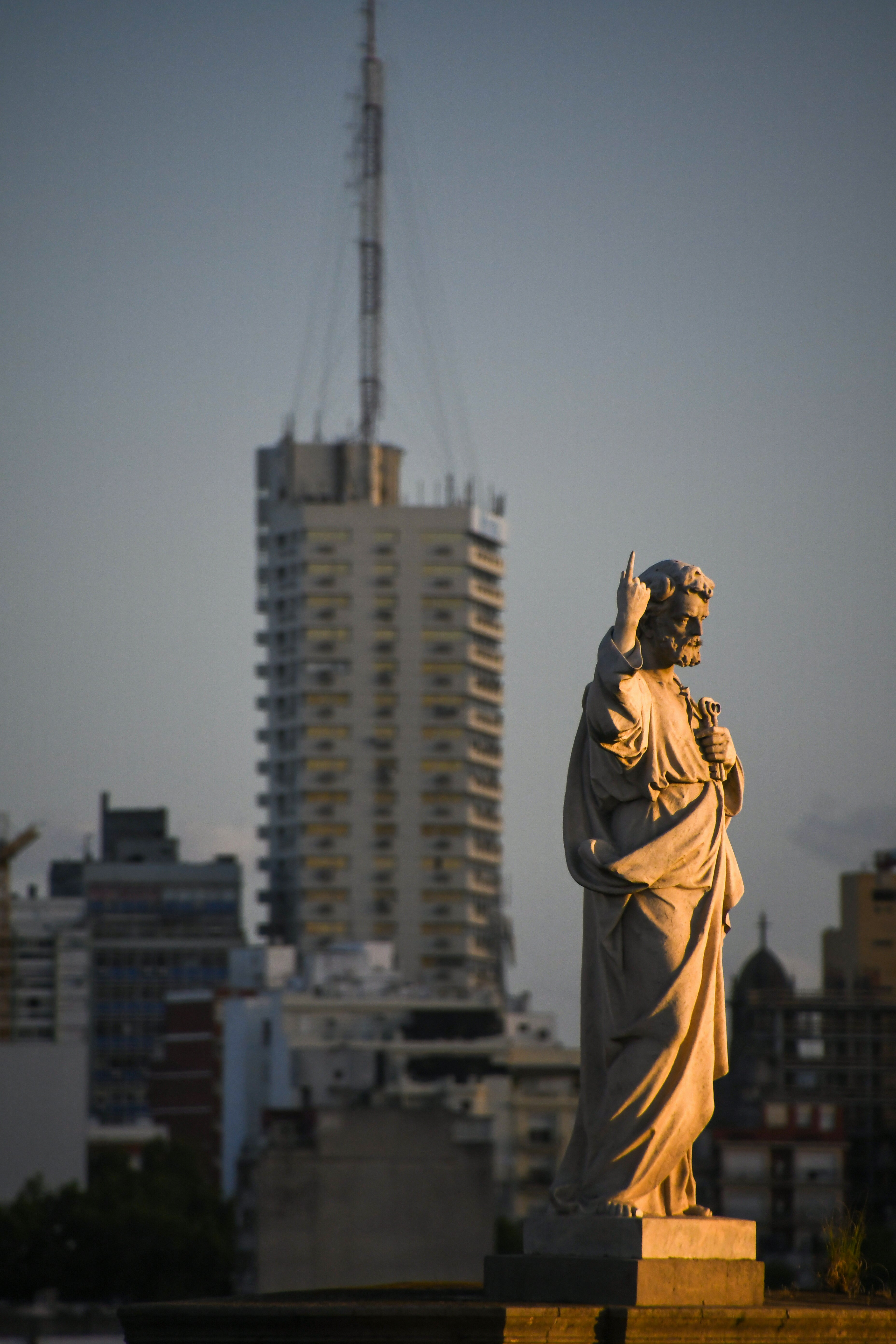 A statue of jesus in front of a city skyline