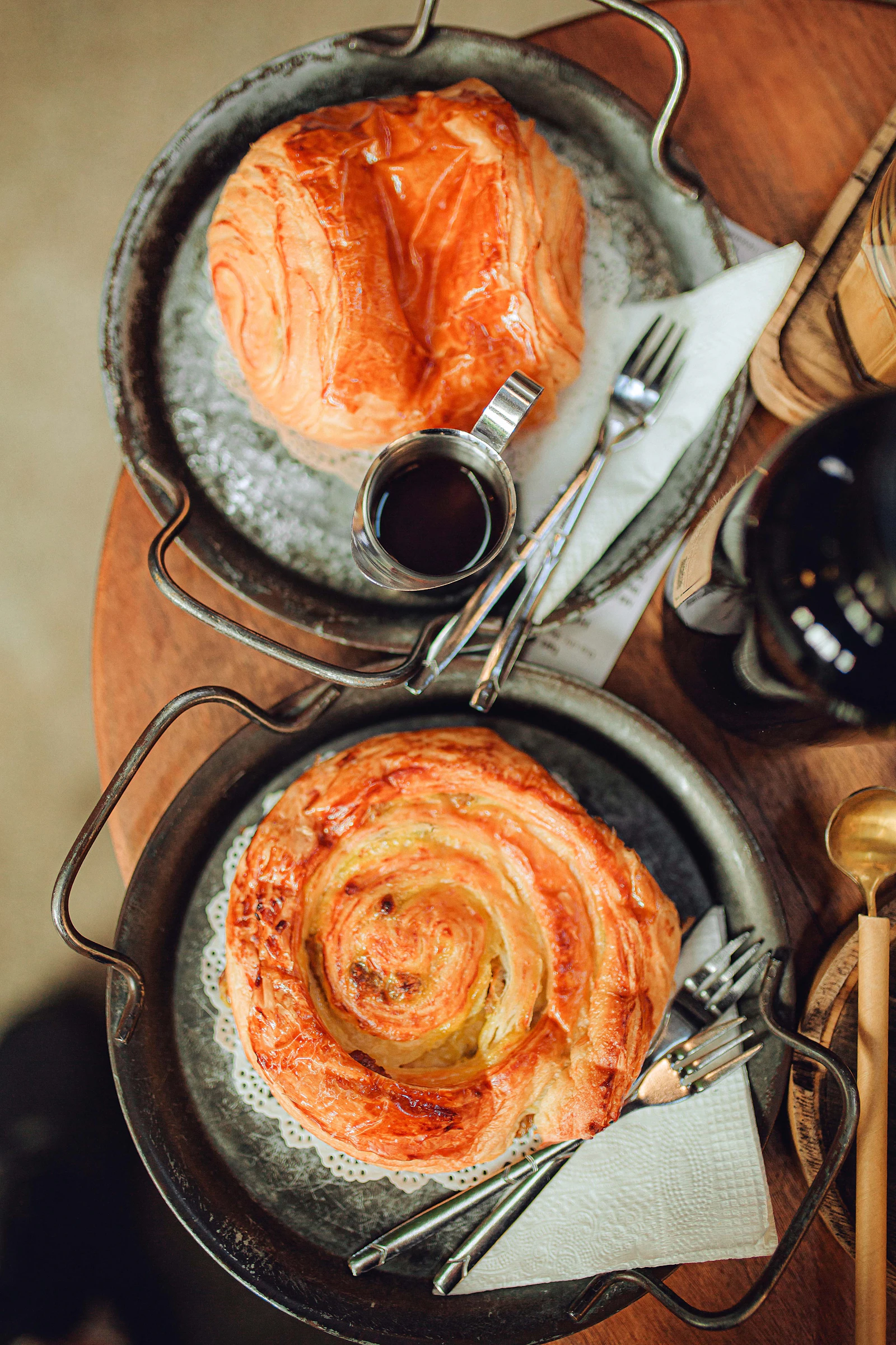 Two pans of food sit on a wooden table.