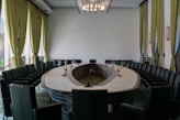 A conference room with a round table and black chairs