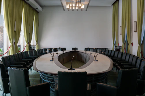 A conference room with a round table and black chairs