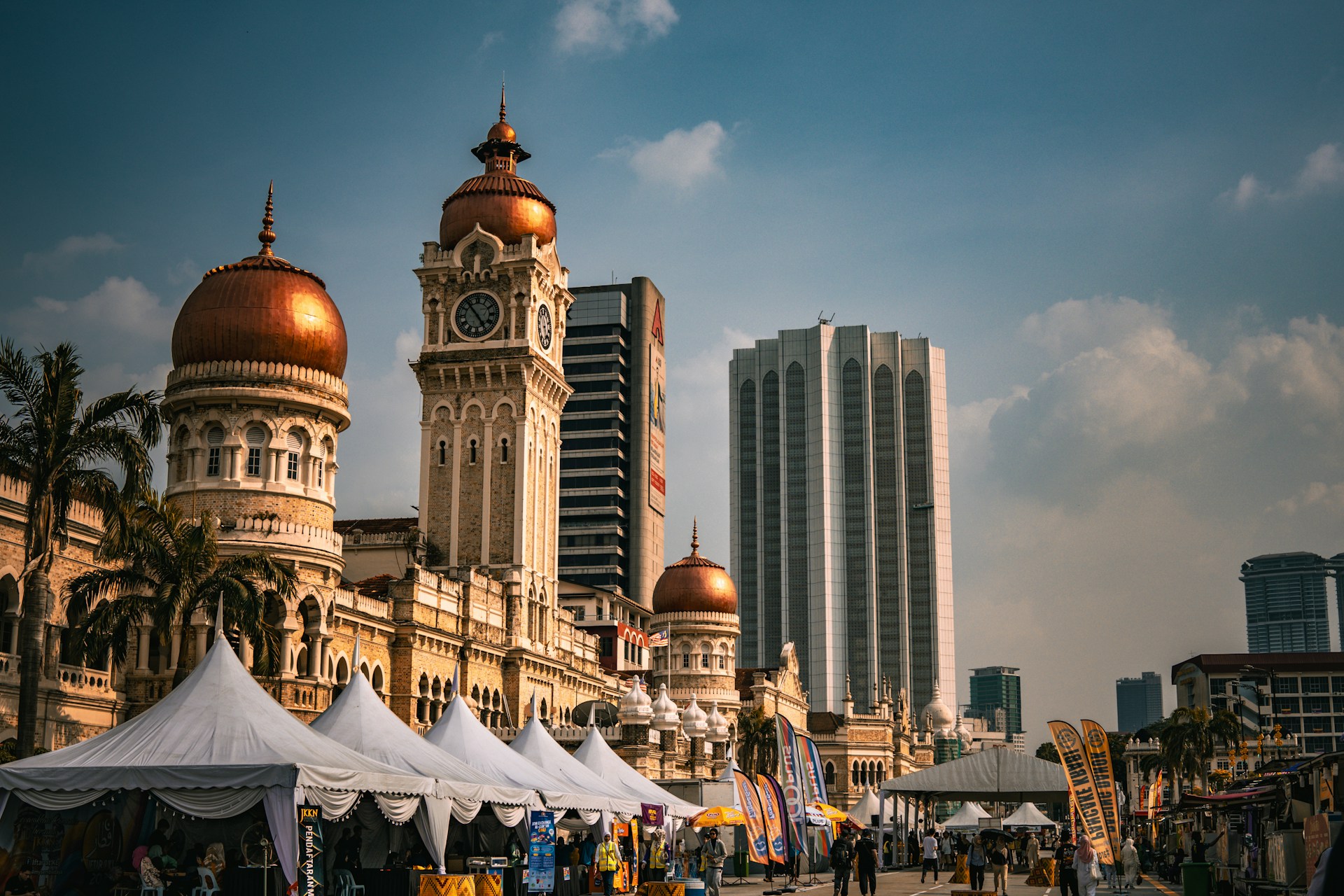 A group of people standing around tents in front of a building