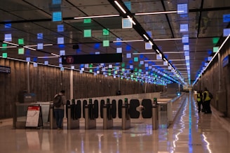 A man is standing in the middle of a long hallway