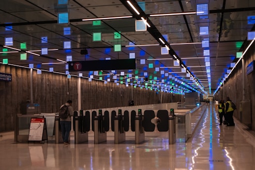 A man is standing in the middle of a long hallway