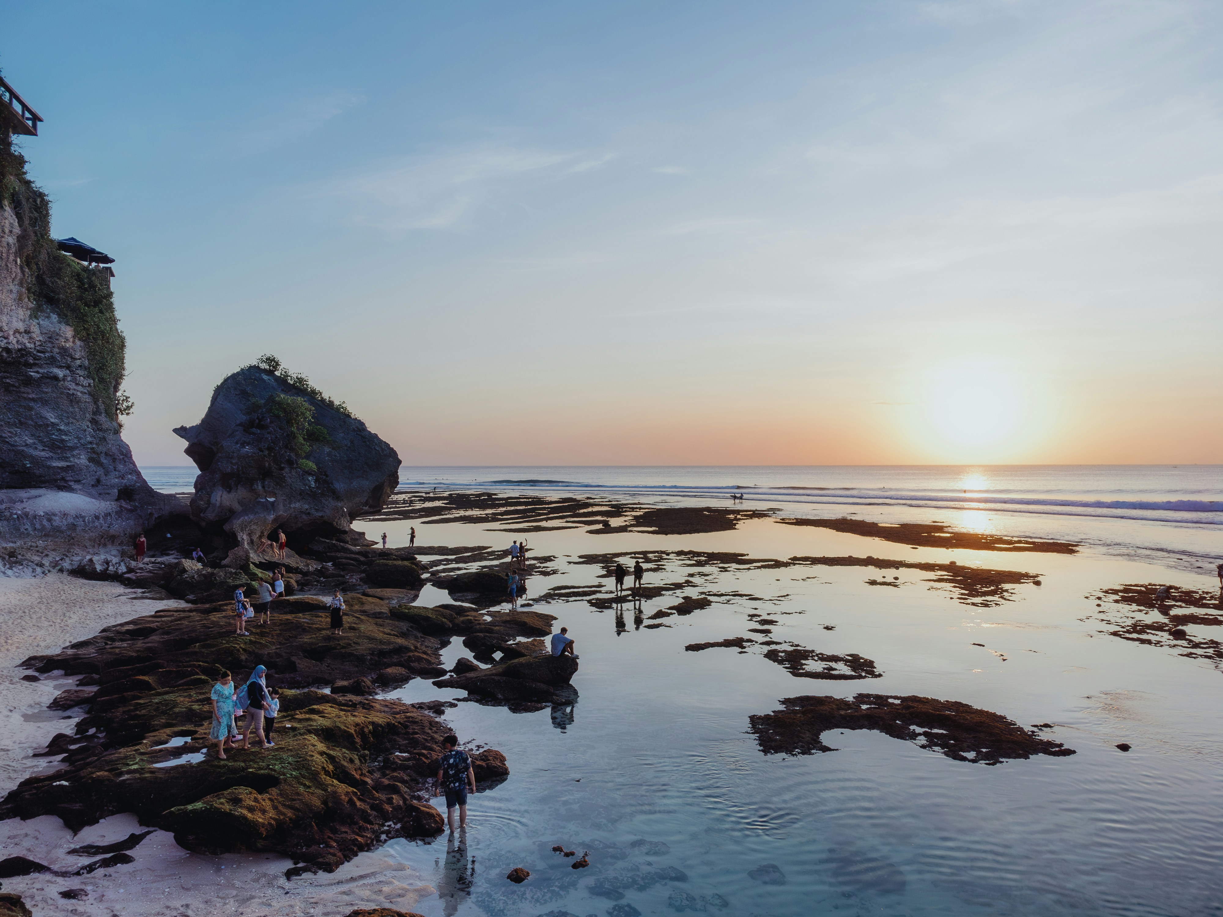 A group of people standing on top of a sandy beach