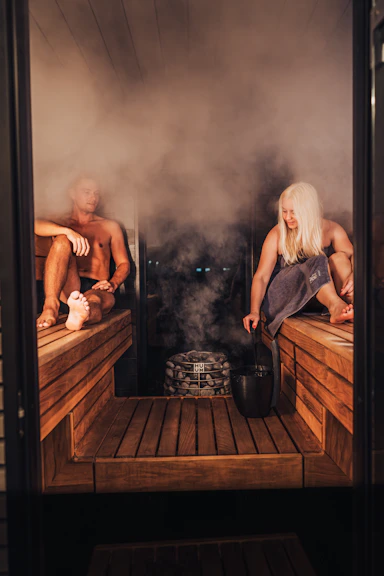 A couple of people that are sitting in a sauna