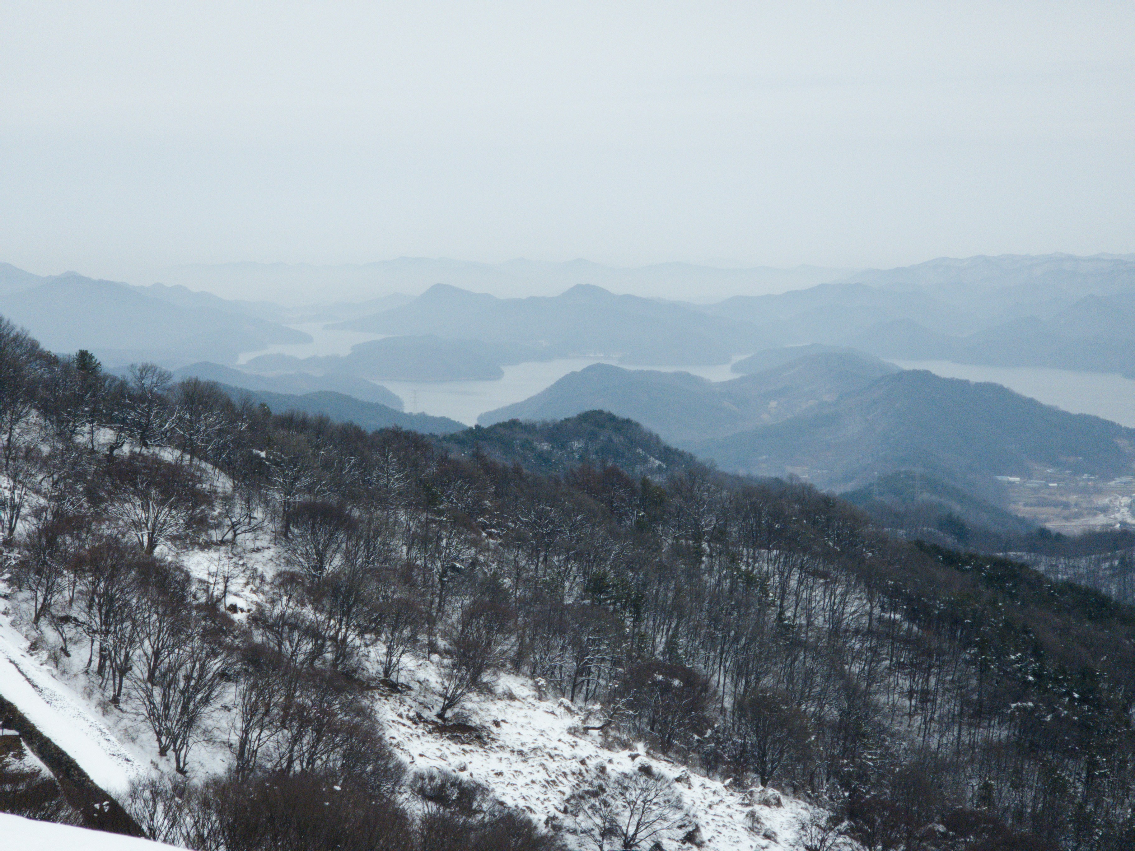 A man riding a snowboard down the side of a snow covered slope