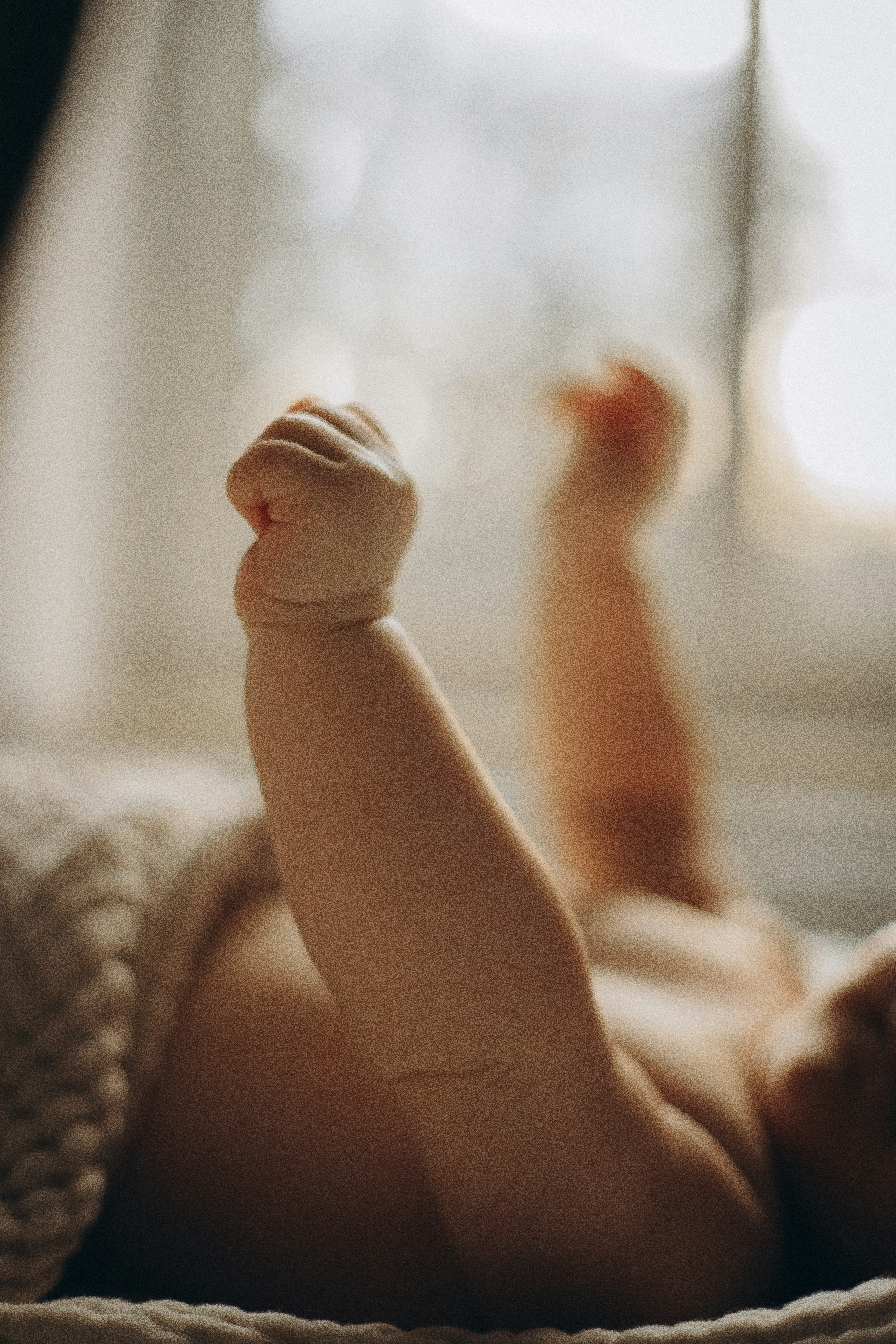 A baby laying on its back on a bed