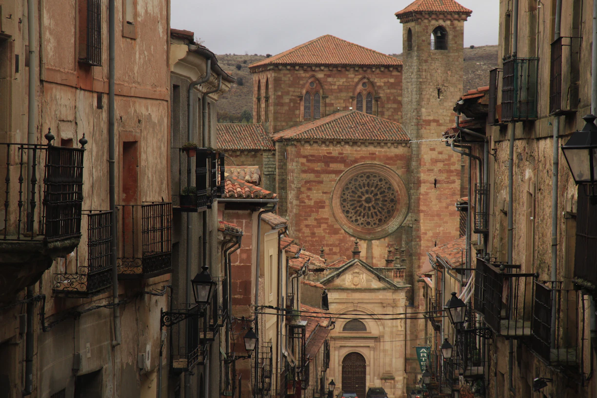 A narrow alley way with a church in the background