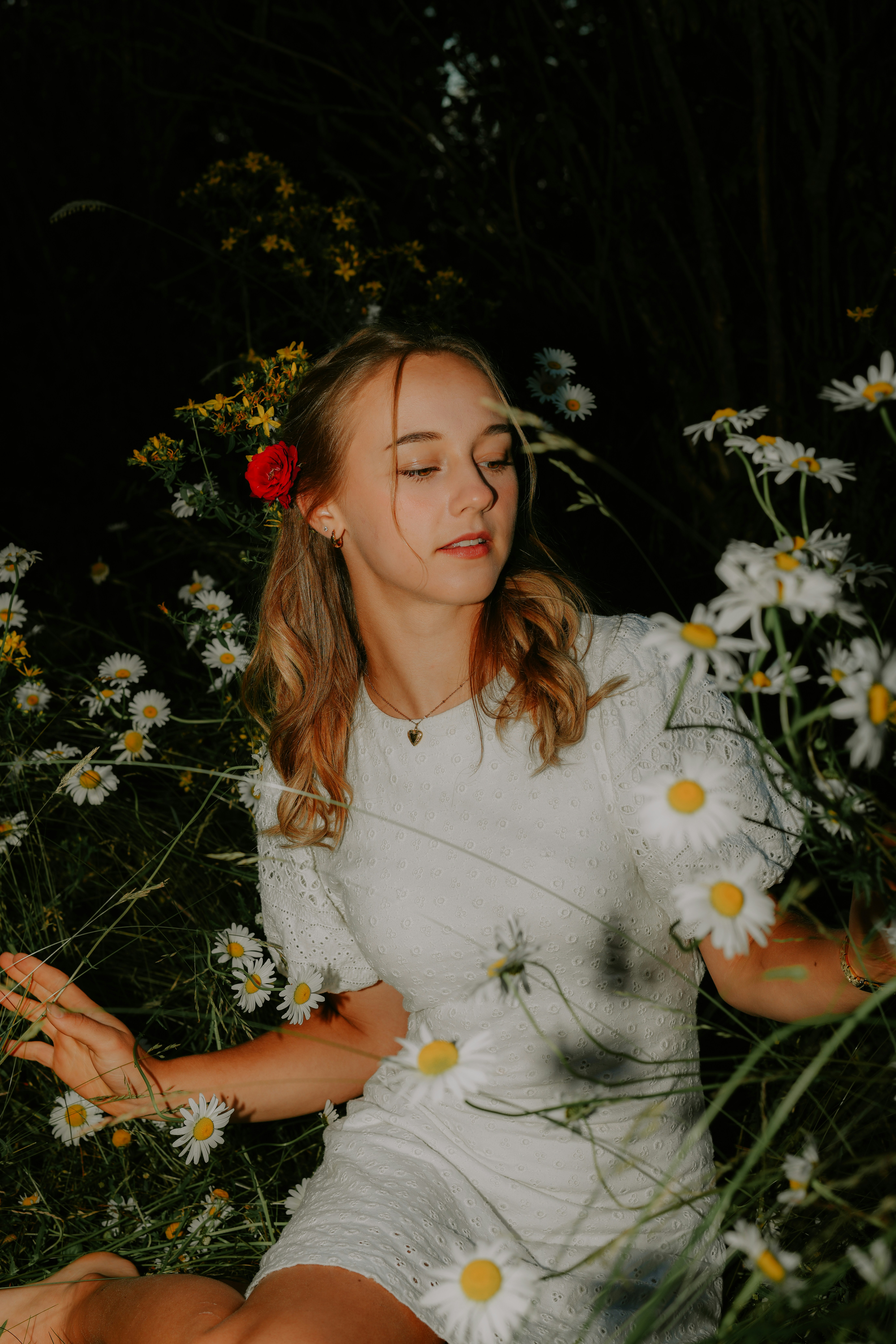 A woman sitting in a field of daisies