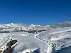 A person standing on top of a snow covered slope
