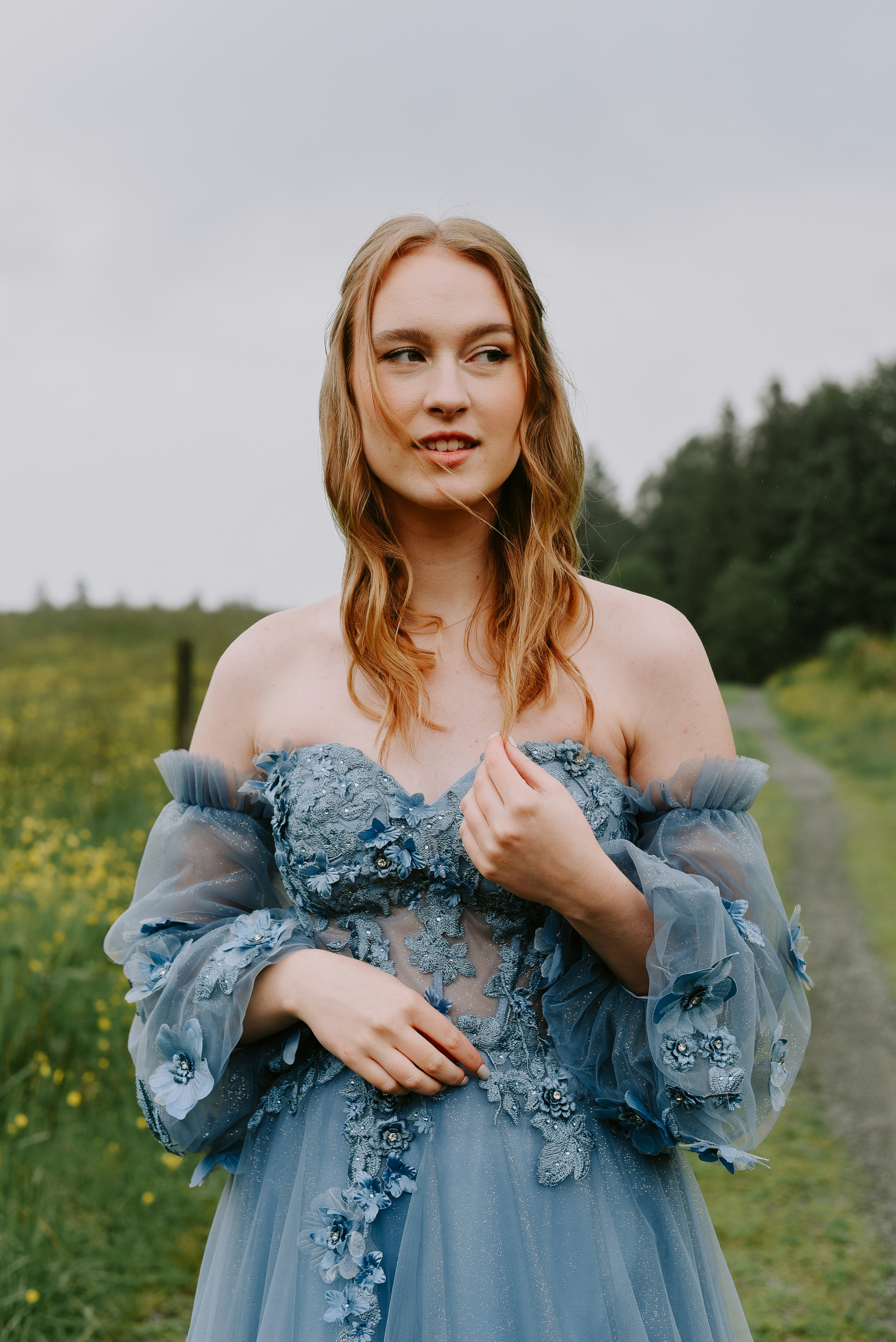 A woman in a blue dress standing in a field