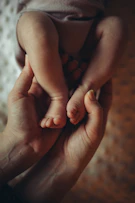 A person holding a baby in their hands