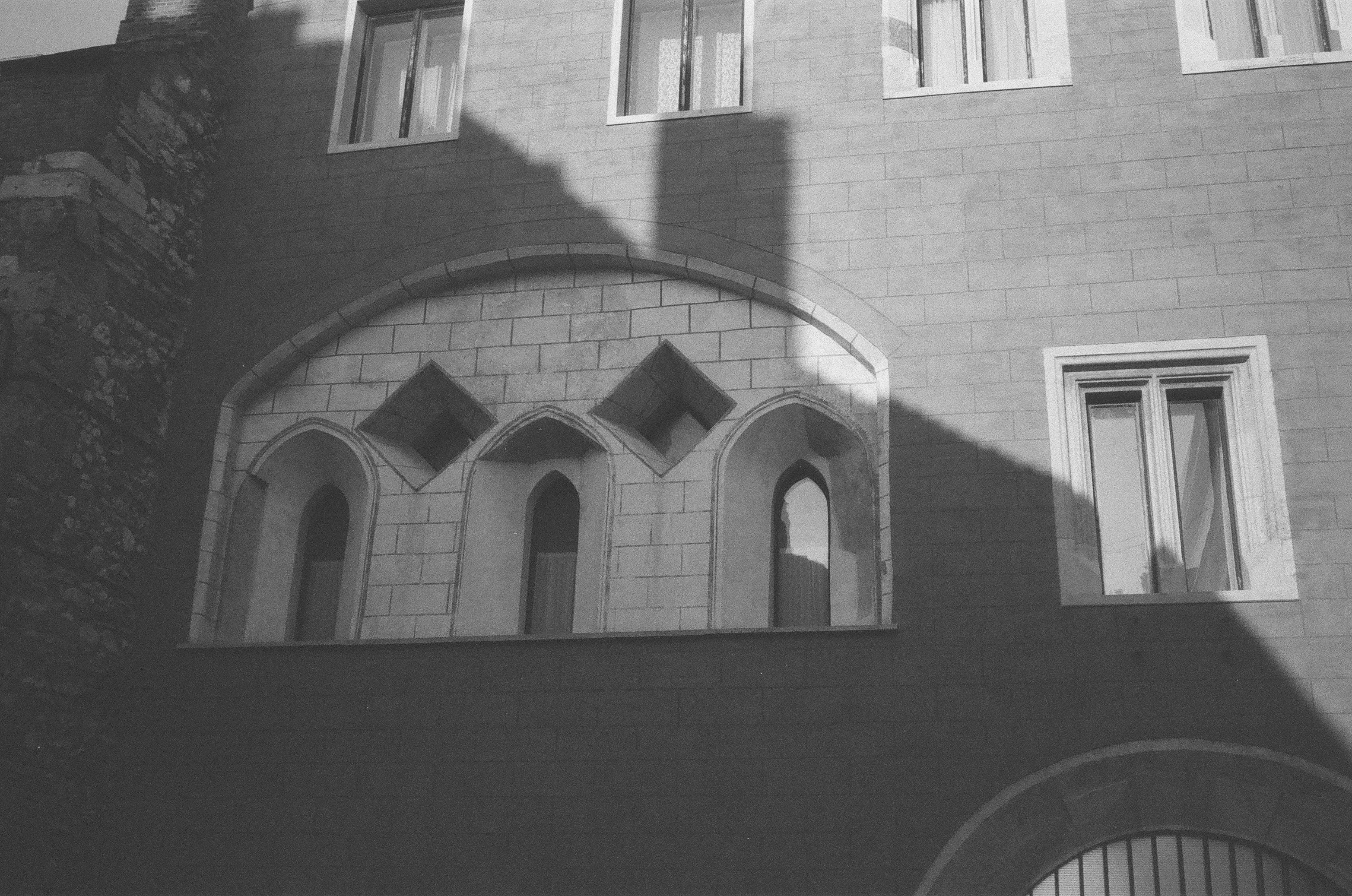 Une photo en noir et blanc d’un bâtiment avec des fenêtres cintrées