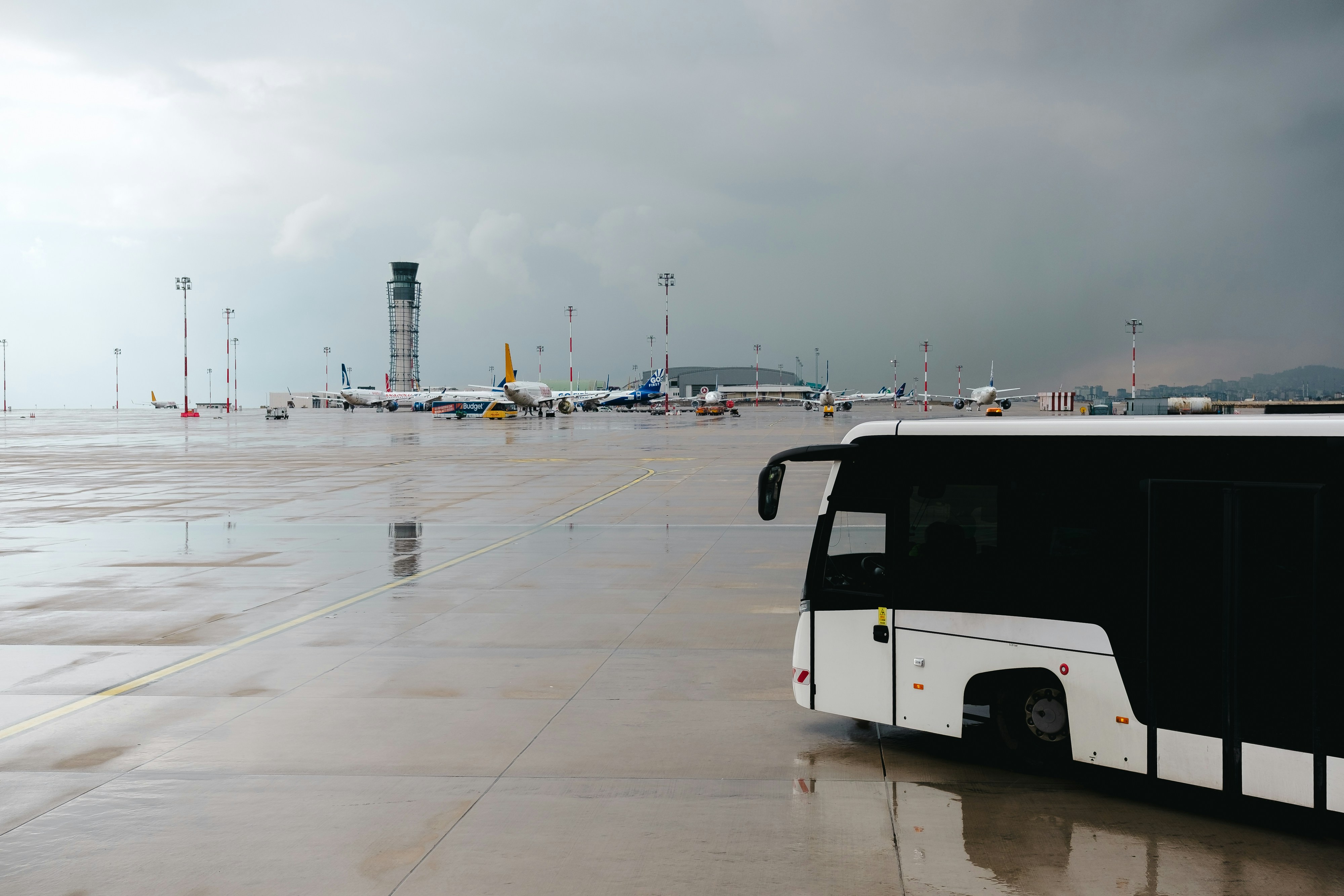 A black and white bus parked in a parking lot, 