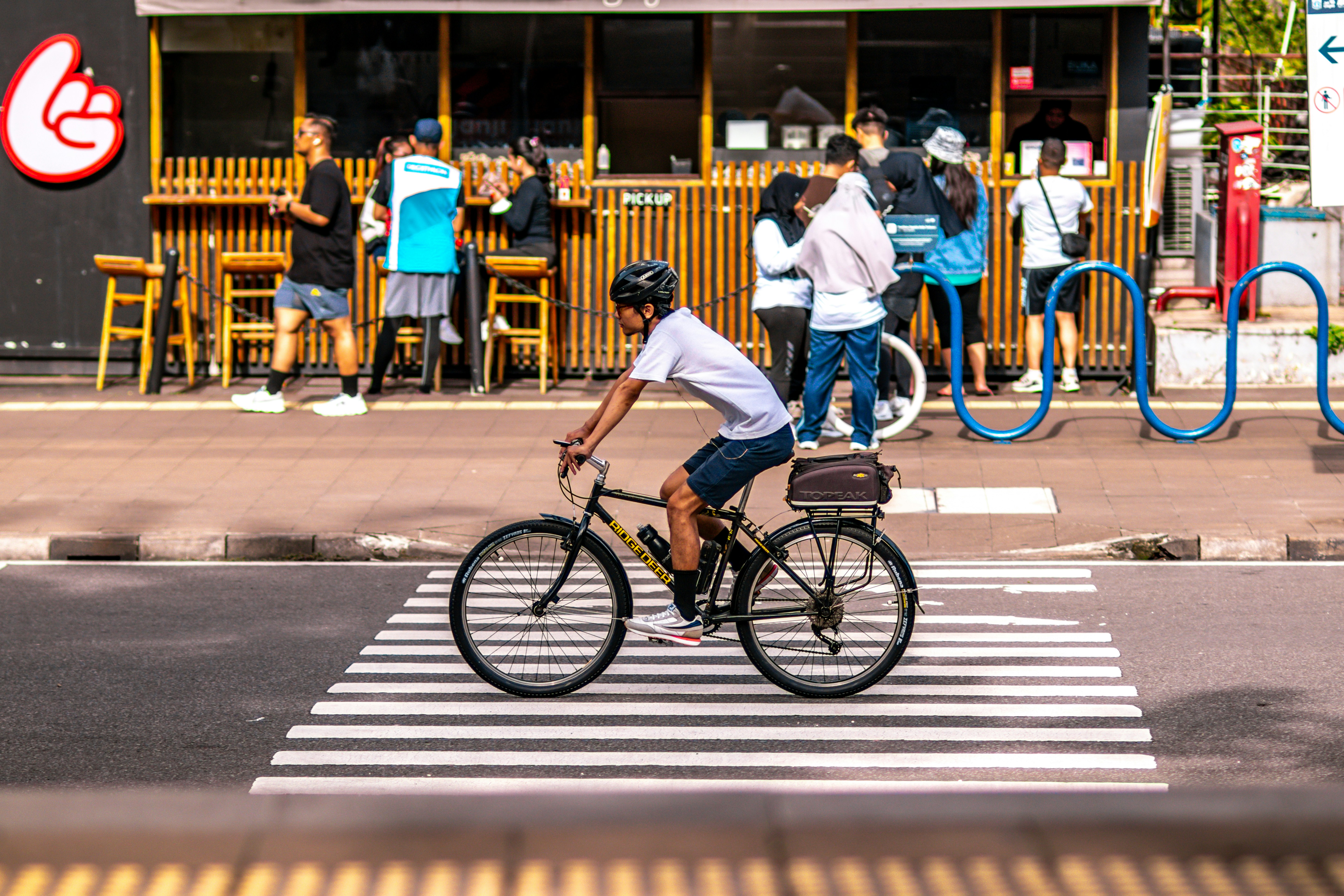 A man riding a bike across a cross walk