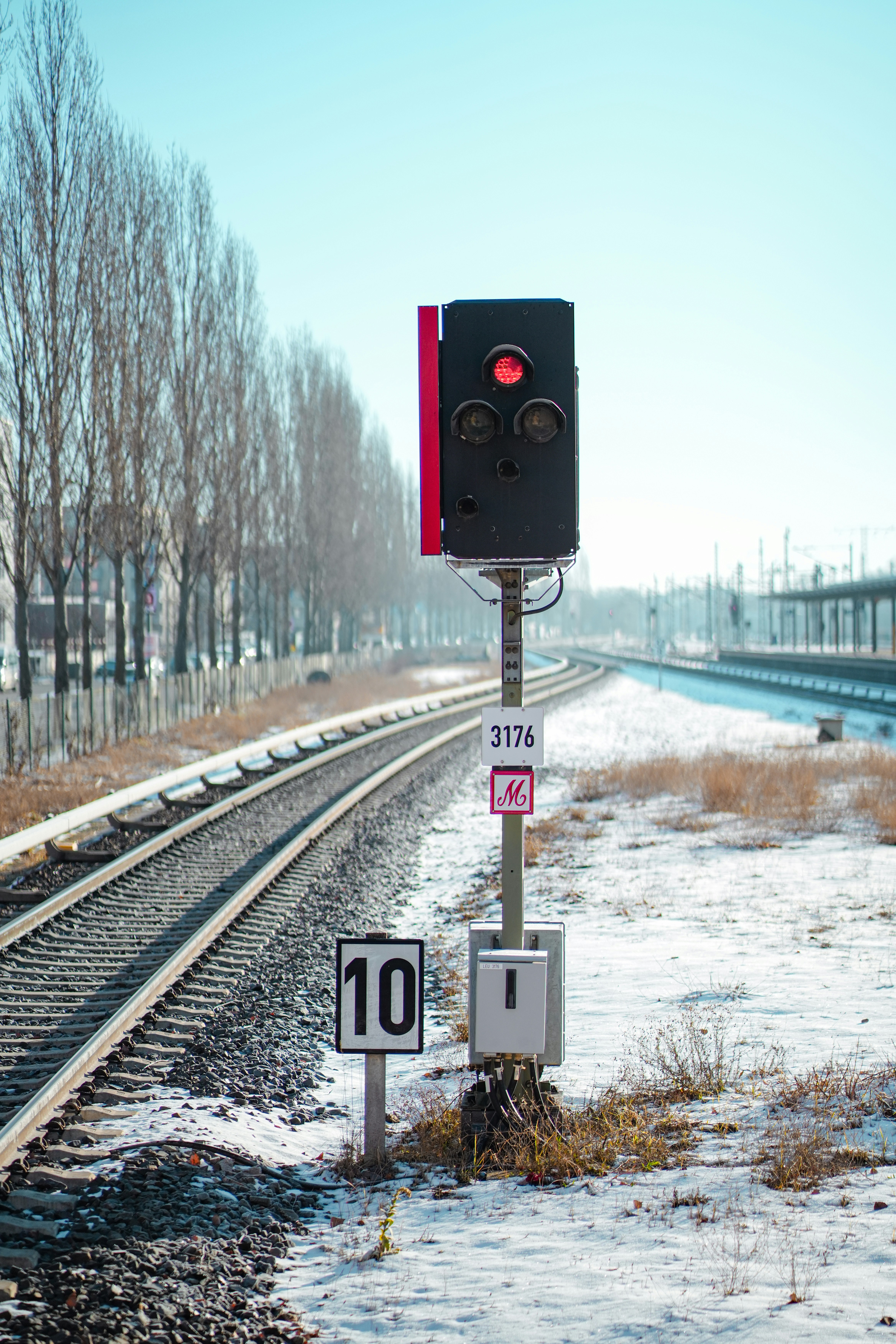 Un semáforo sentado al costado de una vía de tren