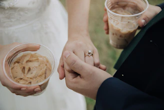 A bride and groom holding hands and holding drinks