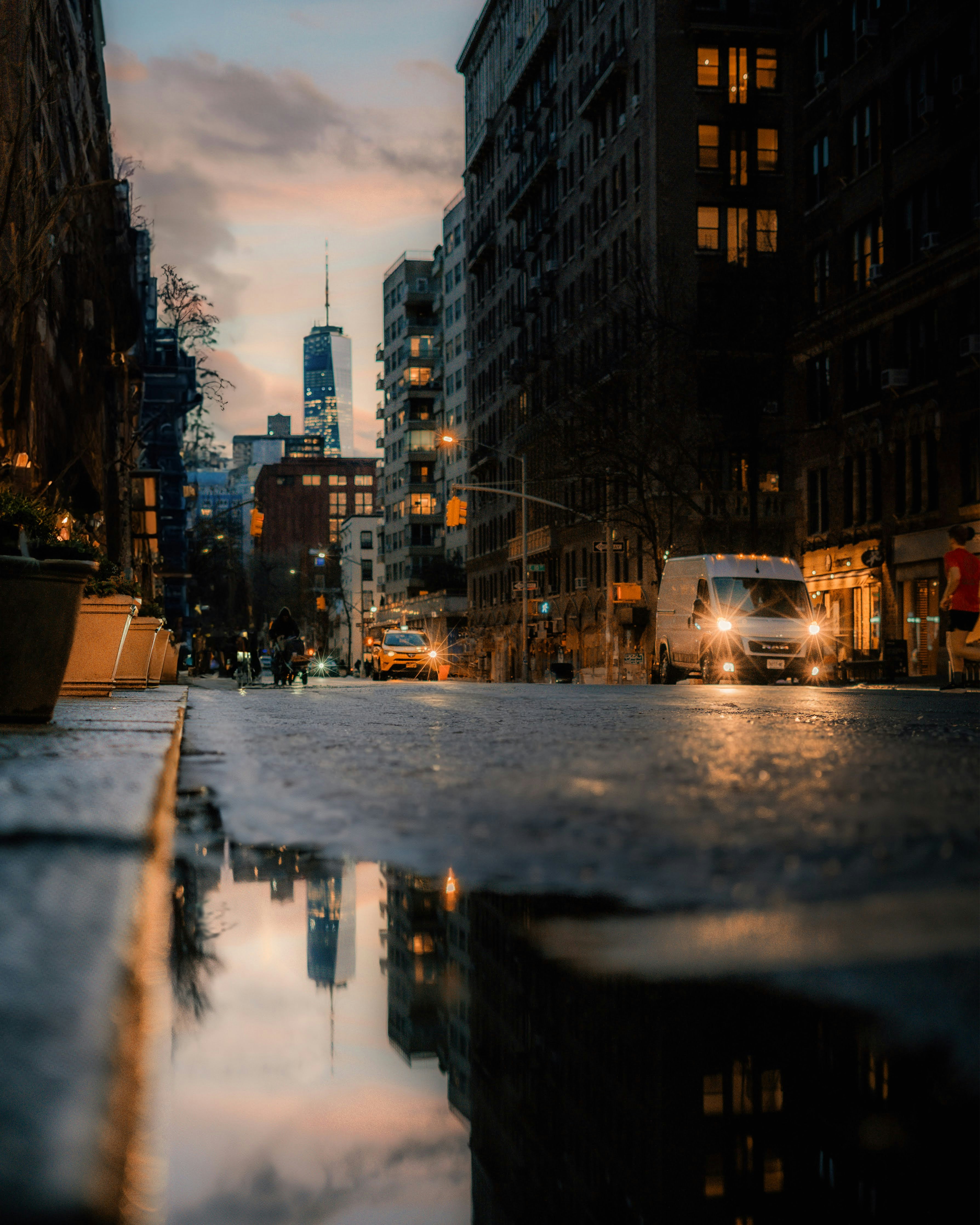 A city street with a puddle of water in the middle of it