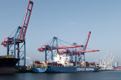 A large cargo ship in a harbor with cranes